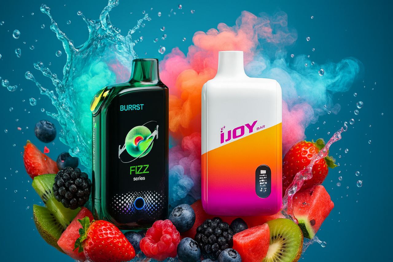 A vibrant close-up of two large, rectangular vape devices, one black/green and one white/orange, set against a blue backdrop. They are flanked by a dramatic cloud of contrasting vapor and splashing water, and surrounded by an array of fresh fruits like strawberries, kiwi, watermelon, and various berries.